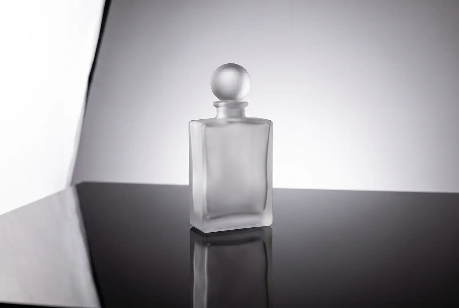 Packshots 1 Studio packshot of an unbranded frosted glass bottle with reflection, product photography service