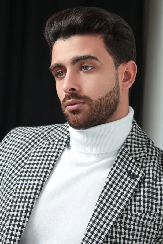 Your First Photoshoot in Casablanca: What to Bring and What to Expect 3 Studio portrait of a man in a houndstooth jacket and white turtleneck against a dark background, by Alex Bego